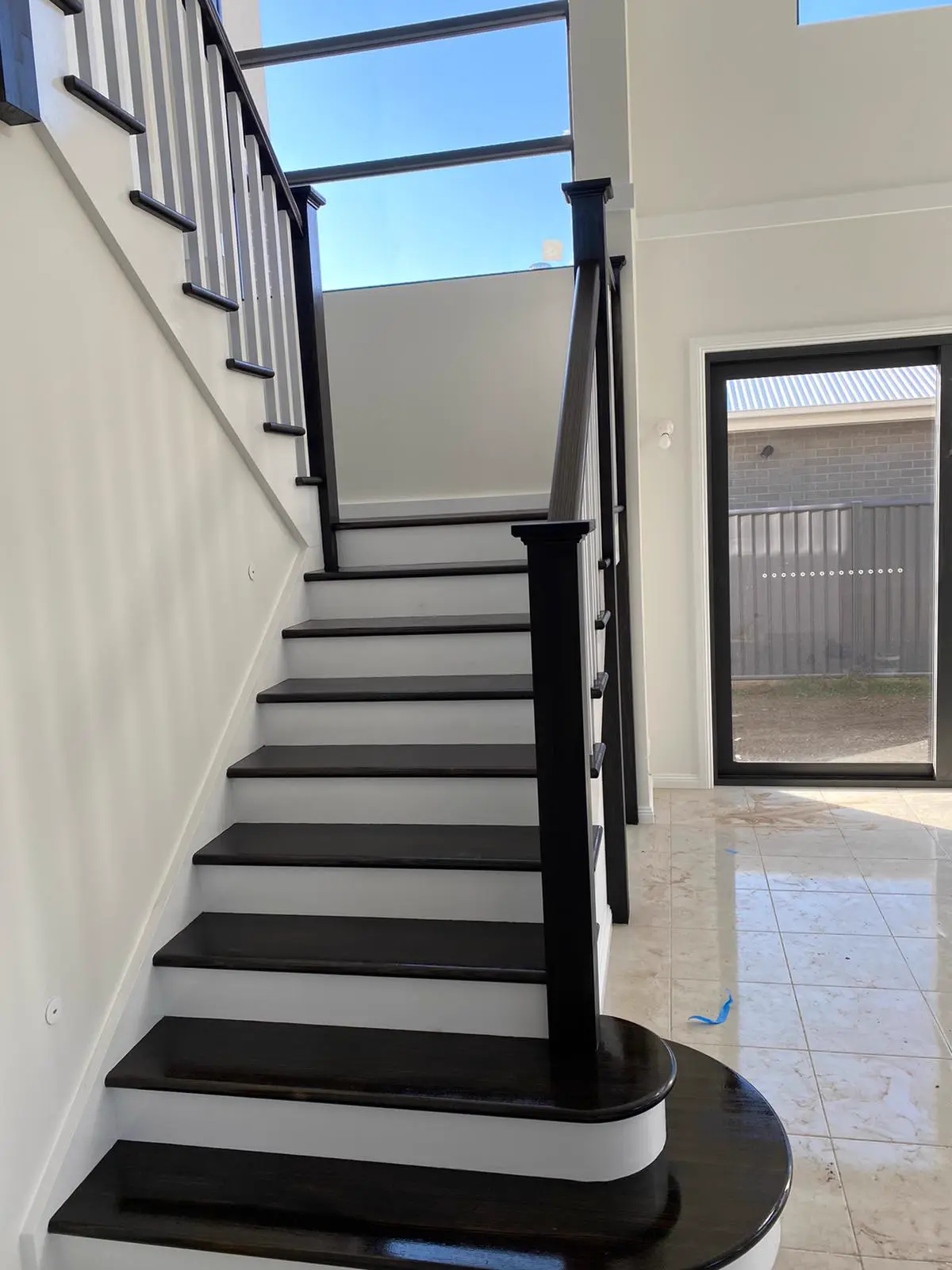 Black and white staircase with freshly painted risers and balustrade
